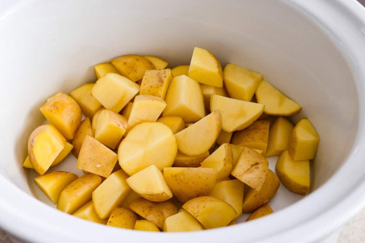 This viral slow cooker Parmesan garlic chicken has juicy meat, tender potatoes, and a sauce so rich and creamy that scooping it with a spoon wonโt cut it. Youโll want to drink it, or letโs be real, bathe in it. Potatoes sliced and placed in the bottom of the slow cooker.