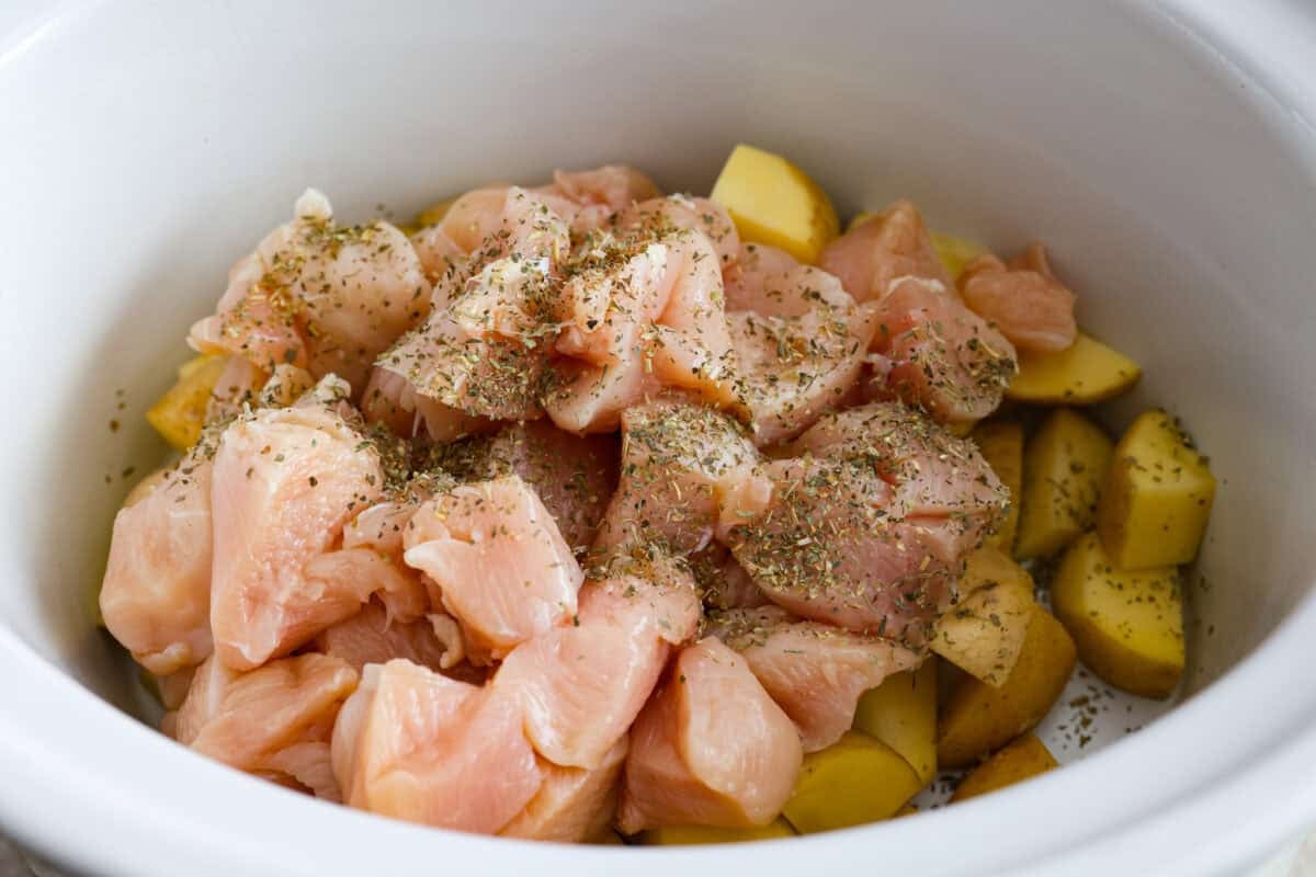 This viral slow cooker Parmesan garlic chicken has juicy meat, tender potatoes, and a sauce so rich and creamy that scooping it with a spoon wonโt cut it. Youโll want to drink it, or letโs be real, bathe in it. Cubed chicken with Italian seasoning placed on top of the potatoes in the slow cooker.