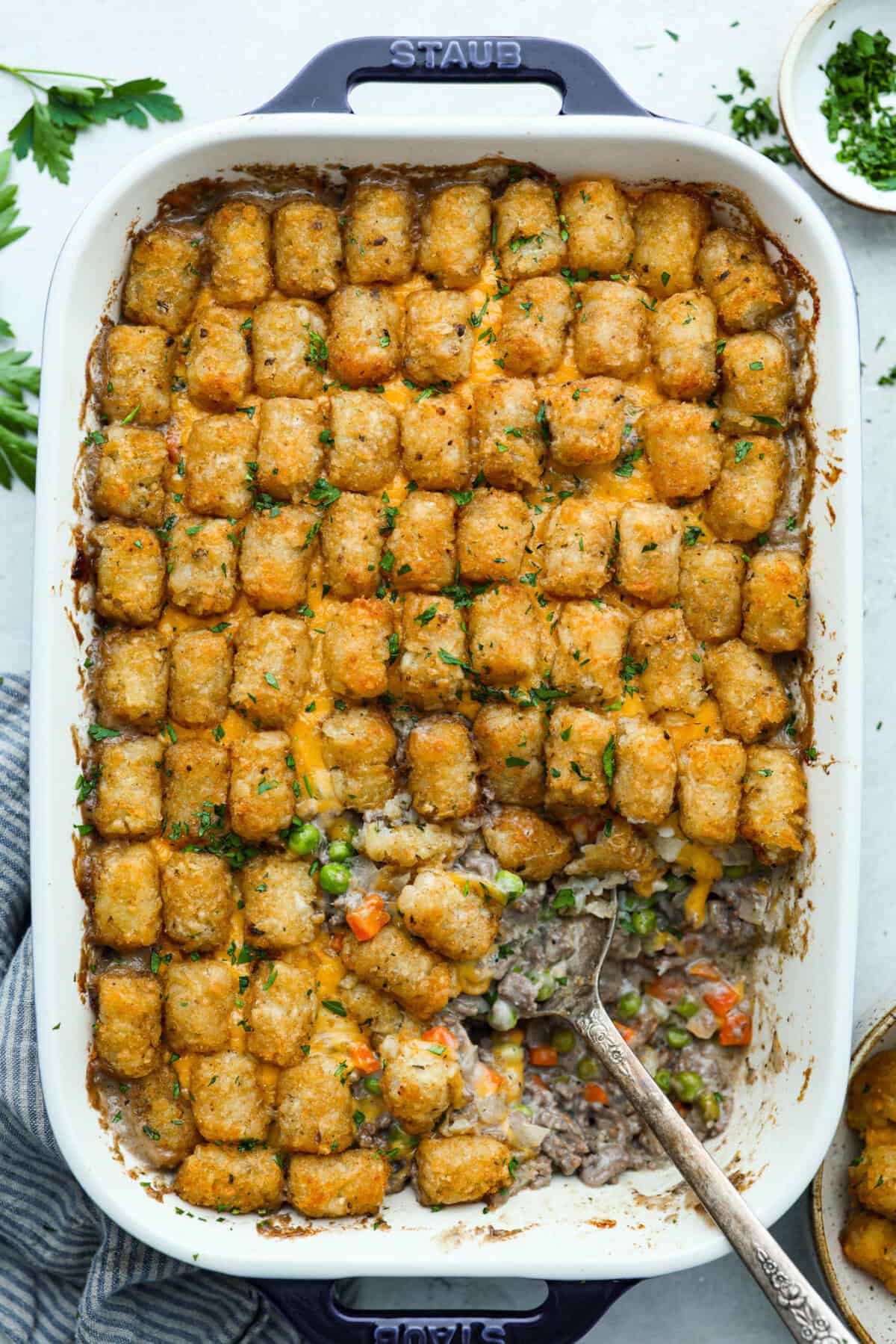 If you love shepherd’s pie, you’ve got to try this Tater Tot Casserole! It’s the ultimate lazy-girl version, with tots instead of mashed potatoes, melty cheese, hearty beef, and total comfort in every bite. The kids will absolutely devour it. Top down view of cooked tater tot casserole.