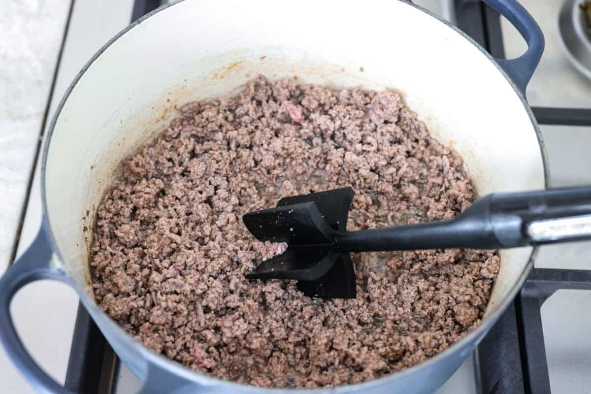I'm telling you right now, this is the BEST chili you will ever have. The reviews don't lie! It's hearty, flavorful, and oh-so-comforting. It's packed with ground beef, beans, tomatoes, and bold spices. Get creative with your toppings and dig in! Ground beef cooking in a pot.