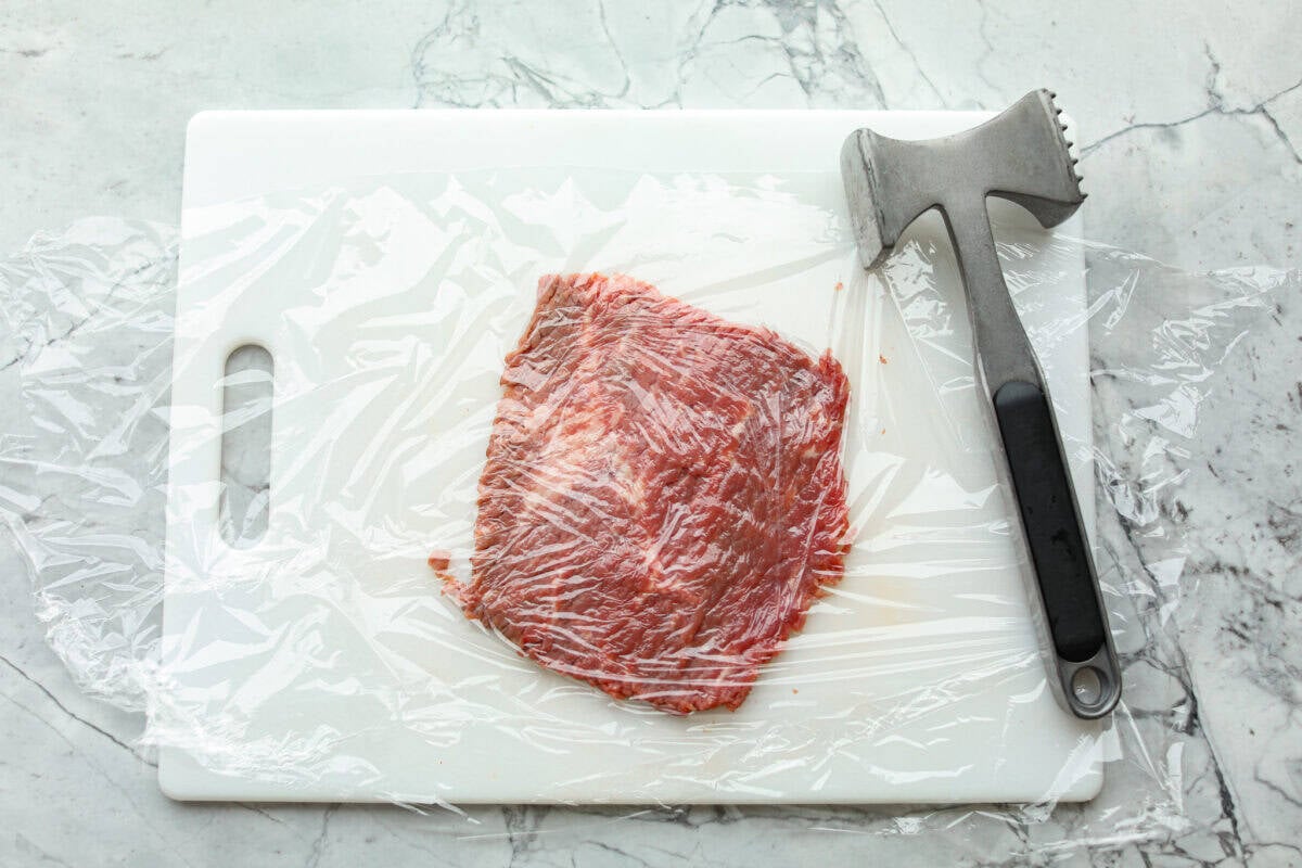 Cube steaks are my go-to budget comfort food. They're quick, cozy, and smothered in gravy. I love them with mashed potatoes or veggies, and I’ve got a simple trick to keep them melt-in-your-mouth tender every time. Steak covered in plastic wrap smashed with a mallet.