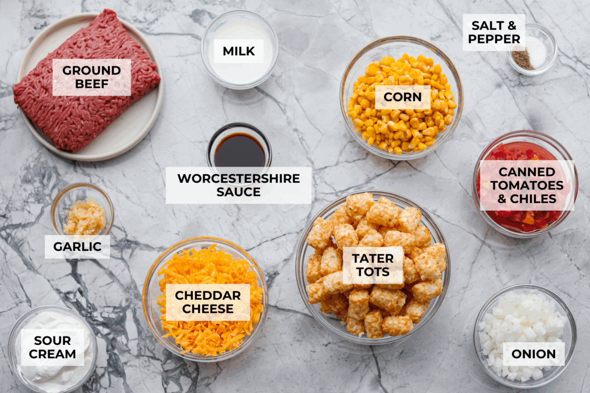 Cowboy casserole is my ultimate mom hack. Beef, cheese, corn, and tater tots, whatโs not to love? Even the picky eaters mysteriously forget how to be picky. Overhead shot of labeled cowboy casserole ingredients.