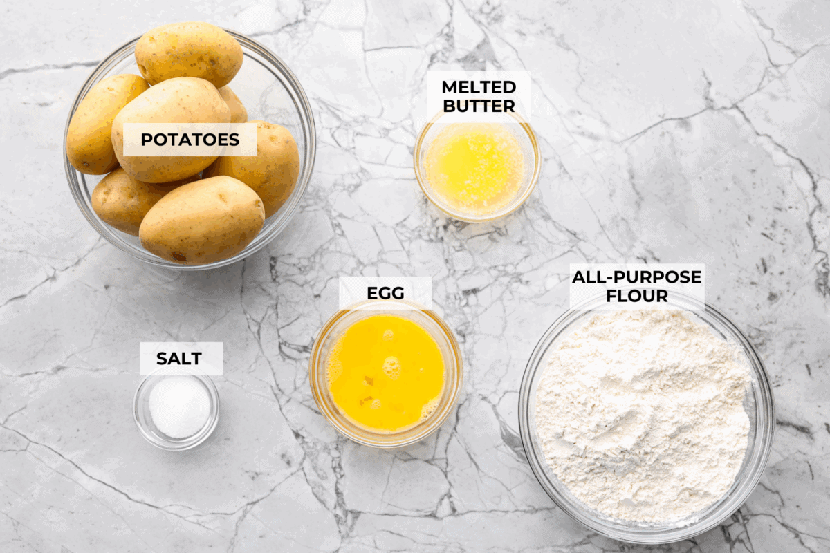 Homemade potato gnocchi is easier than you think! With just 5 simple ingredients, you can make soft, pillowy gnocchi at home. I’ll walk you through each step with clear instructions so you can master this classic Italian recipe on your first try. Overhead shot of labeled homemade potato gnocchi ingredients.