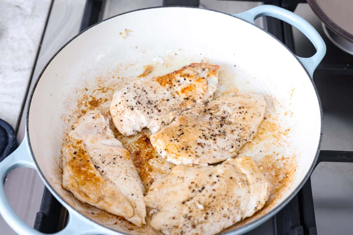 Tuscan garlic skillet chicken is one of those dinners I make and then wonder why I donโt make it more often. Juicy chicken and sun-dried tomatoes all cook together in one skillet. No heavy cream needed. Just fresh, bold flavor in 30 minutes! Chicken cooking in a skillet.