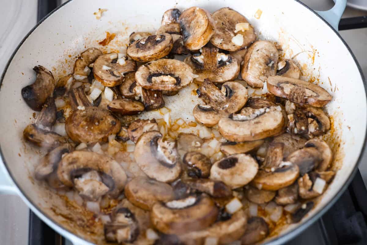 Tuscan garlic skillet chicken is one of those dinners I make and then wonder why I donโt make it more often. Juicy chicken and sun-dried tomatoes all cook together in one skillet. No heavy cream needed. Just fresh, bold flavor in 30 minutes! Mushrooms, onions, and garlic cooking in a skillet.
