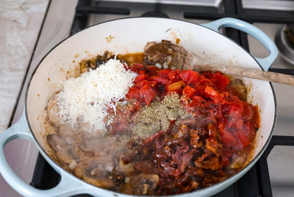 Tuscan garlic skillet chicken is one of those dinners I make and then wonder why I donโt make it more often. Juicy chicken and sun-dried tomatoes all cook together in one skillet. No heavy cream needed. Just fresh, bold flavor in 30 minutes! Tomatoes and seasonings added to the mushrooms.