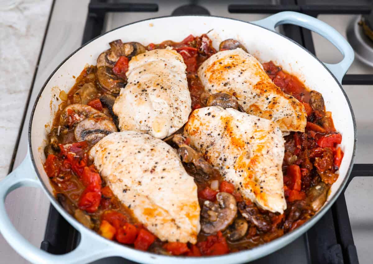 Tuscan garlic skillet chicken is one of those dinners I make and then wonder why I donโt make it more often. Juicy chicken and sun-dried tomatoes all cook together in one skillet. No heavy cream needed. Just fresh, bold flavor in 30 minutes! Chicken added back to the veggies in the skillet.