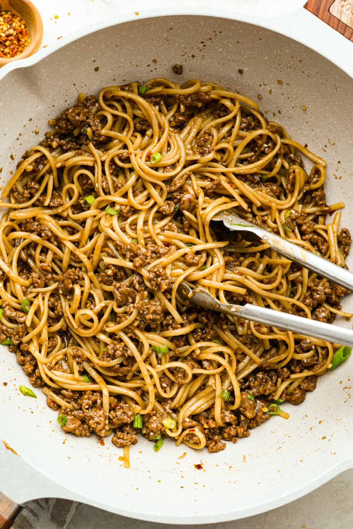 You guys are obsessed with my Korean Ground Beef rice bowls, so I decided I needed a noodle version. Tender beef, savory goodness, and those irresistible Korean flavors all wrapped up in one slurp-worthy Korean Beef Noodle dish. Overhead shot of a skillet with Korean beef noodles in it.