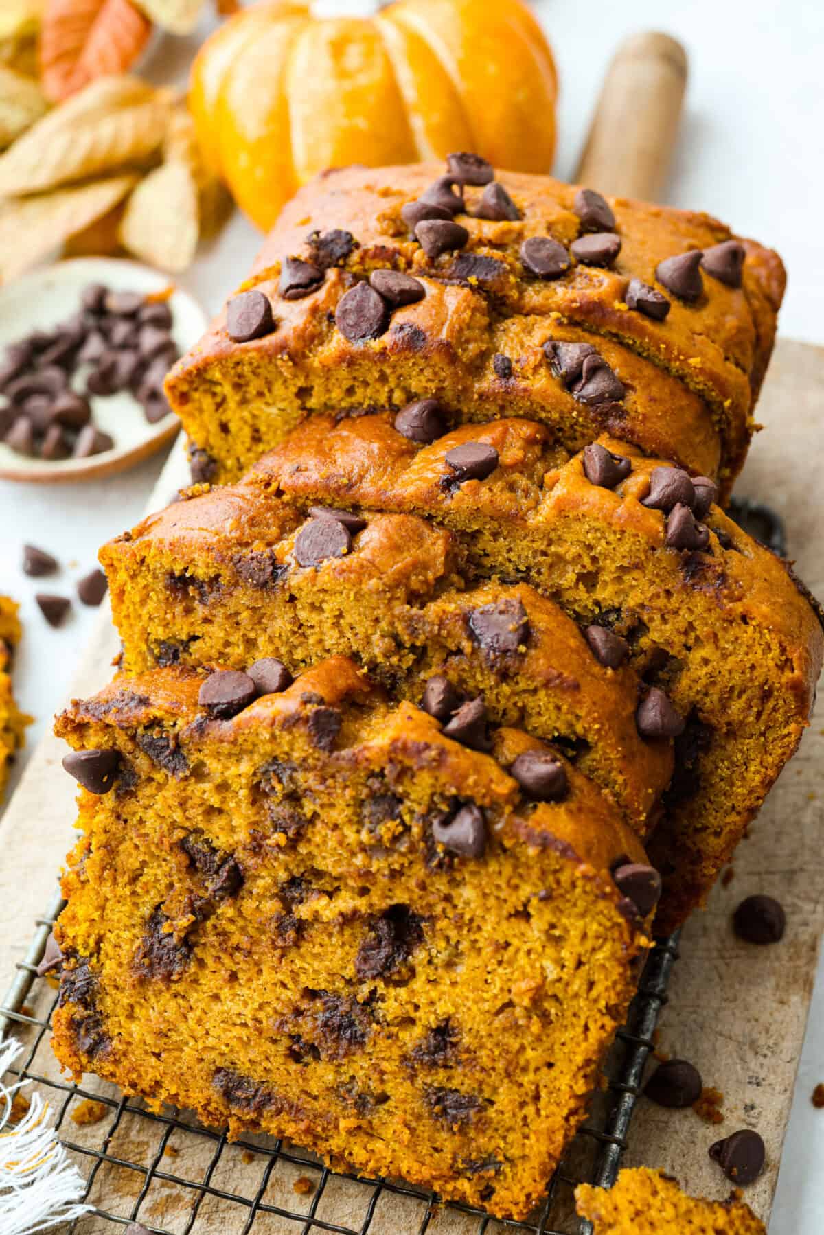 Iโm never one to wait for fall to make my pumpkin chocolate chip bread. I just canโt resist that sweet, chewy bread loaded with rich chocolate chips. Who says you have to wait for pumpkin season? Not me! Pumpkin chocolate chip bread loaf cut in slices.
