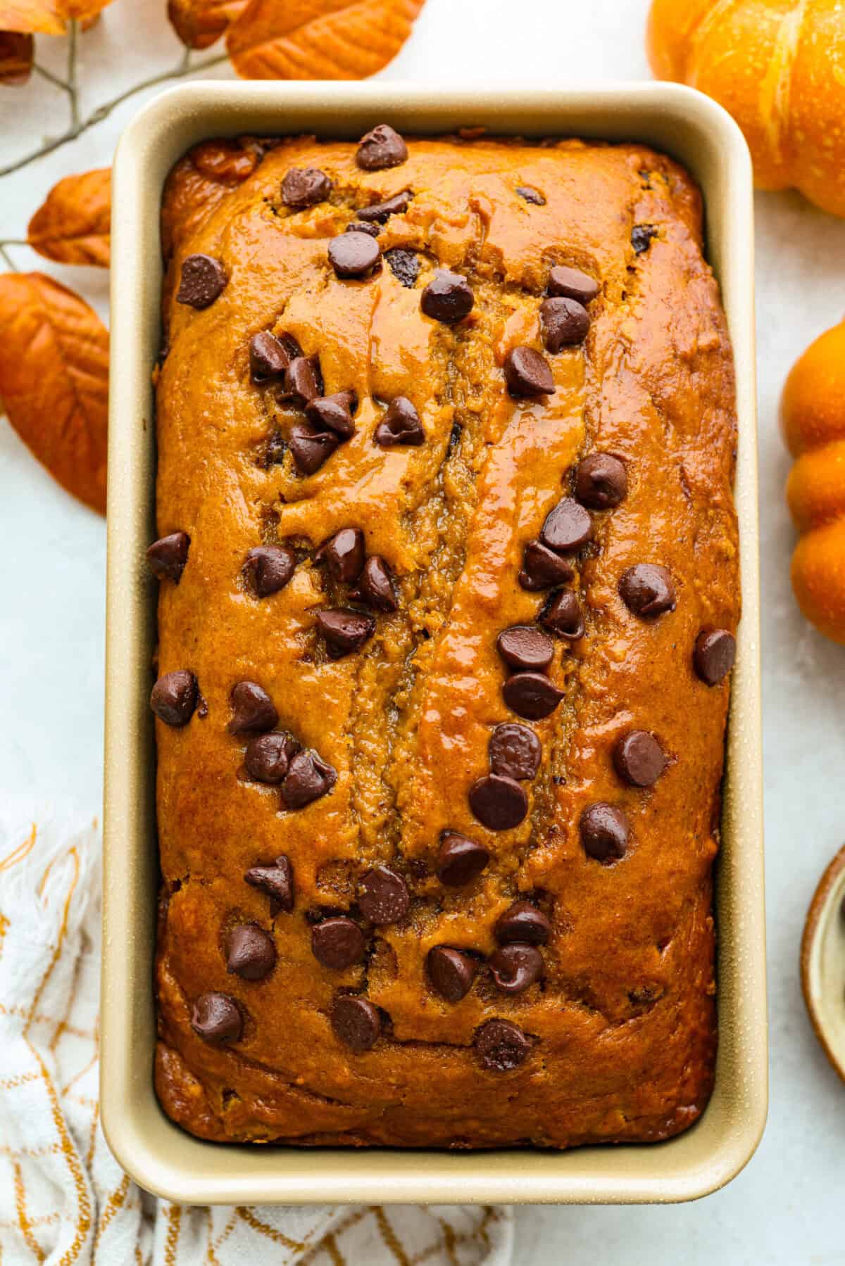 Iโm never one to wait for fall to make my pumpkin chocolate chip bread. I just canโt resist that sweet, chewy bread loaded with rich chocolate chips. Who says you have to wait for pumpkin season? Not me! Overhead shot of a loaf of pumpkin chocolate chip bread.