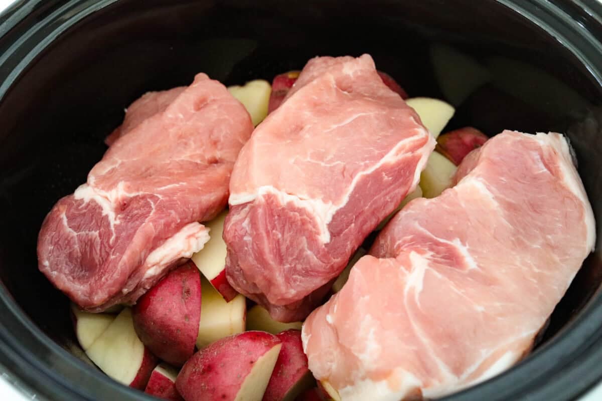 Weeknight magic in one pot! These slow cooker ranch pork chops are rich, comforting, and packed with flavor. With just a few ingredients, you’ll have tender pork and perfectly cooked potatoes swimming in a creamy ranch sauce. Pork chops placed on top of the potatoes.