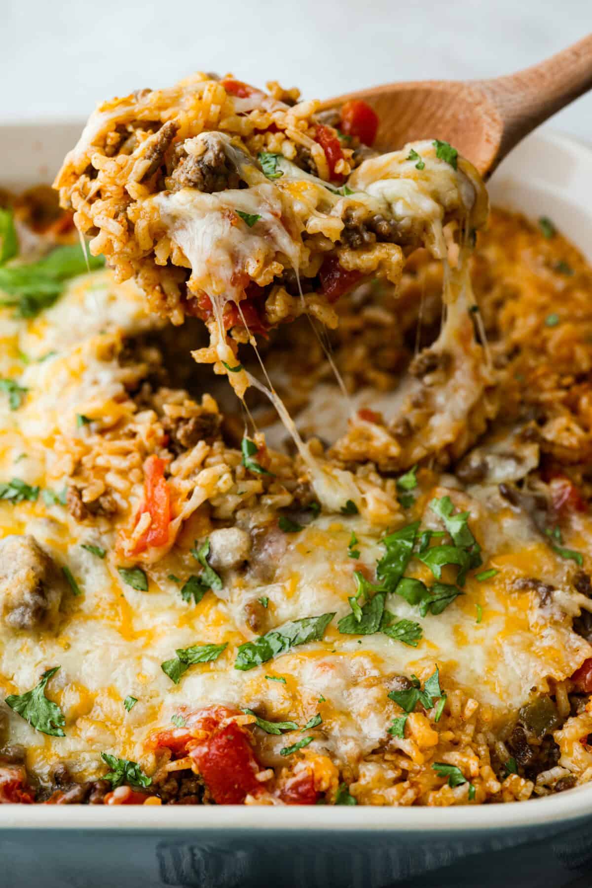 This is about to change your taco game forever! No shell needed! This dump-and-go taco rice is so easy and made with just 6 ingredients. Throw it together, top it your way, and boom, youโve got a totally unique and delicious taco night! Someone lifting a scoop of taco rice out of the main dish.