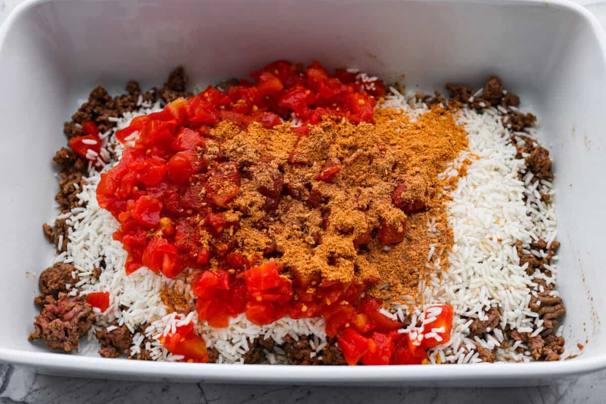 This is about to change your taco game forever! No shell needed! This dump-and-go taco rice is so easy and made with just 6 ingredients. Throw it together, top it your way, and boom, youโve got a totally unique and delicious taco night! Cooked ground beef in the bottom of a casserole dish topped with minute rice, Rotel and taco seasoning.