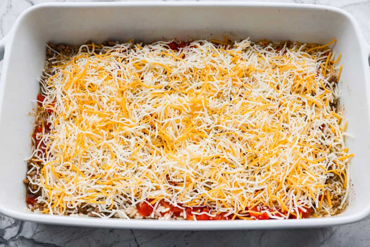 This is about to change your taco game forever! No shell needed! This dump-and-go taco rice is so easy and made with just 6 ingredients. Throw it together, top it your way, and boom, youโve got a totally unique and delicious taco night! Everything mixed together and topped with cheese.