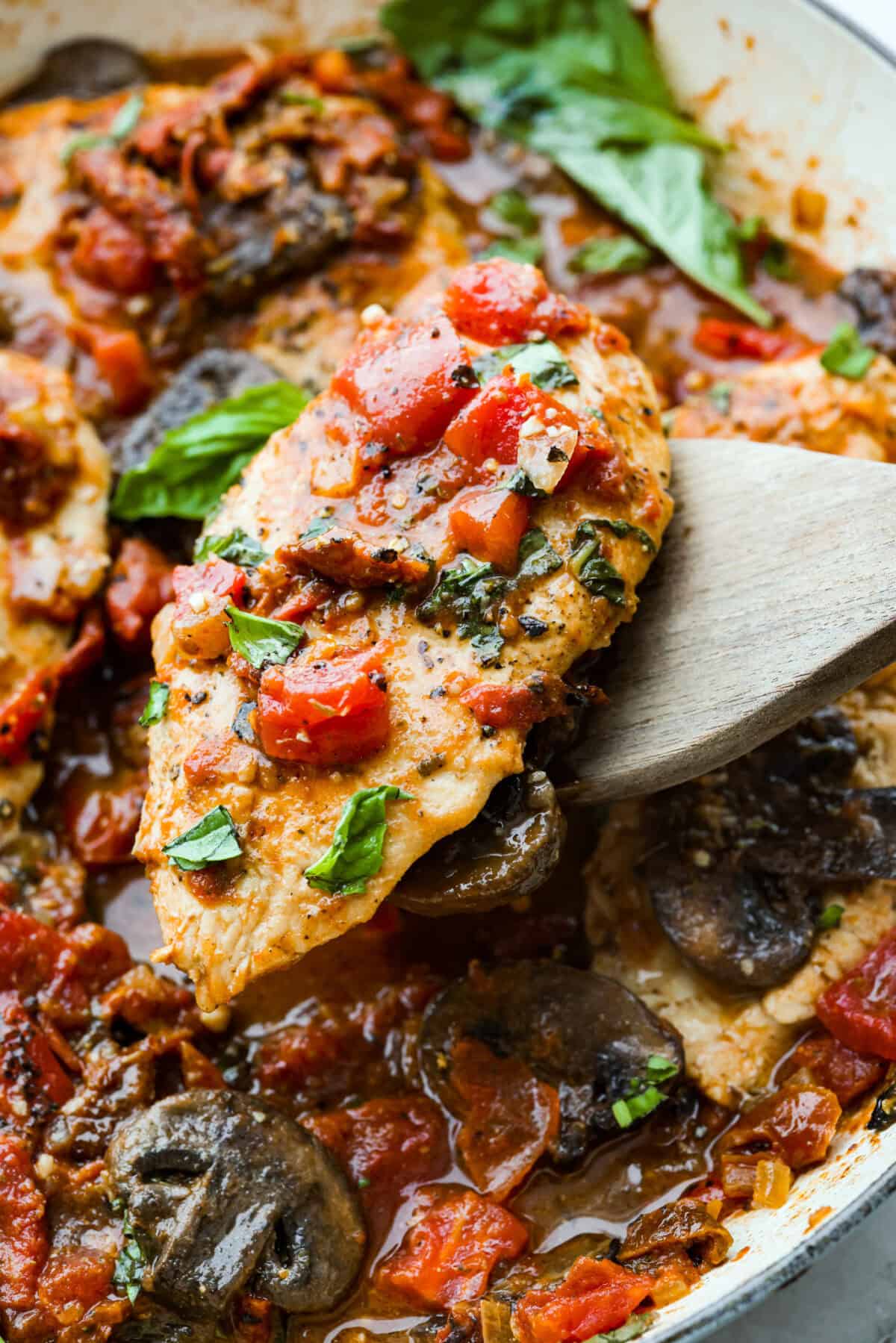 Tuscan garlic skillet chicken is one of those dinners I make and then wonder why I donโt make it more often. Juicy chicken and sun-dried tomatoes all cook together in one skillet. No heavy cream needed. Just fresh, bold flavor in 30 minutes! Close up shot of a Tuscan garlic skillet chicken breast.