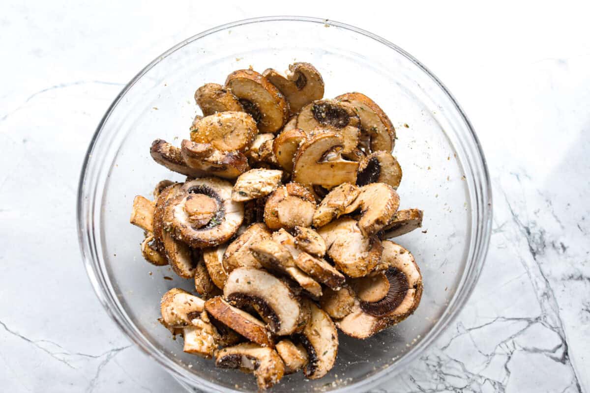 Confession: I never thought I liked mushroomsโฆ until I made these air fryer mushrooms. With garlic parmesan, theyโre juicy, tender, and downright addictive. Even the mushroom skeptics at your table will be fighting over the last bite! Mushrooms in a bowl mixed with the olive oil, soy sauce, parmesan and seasonings.