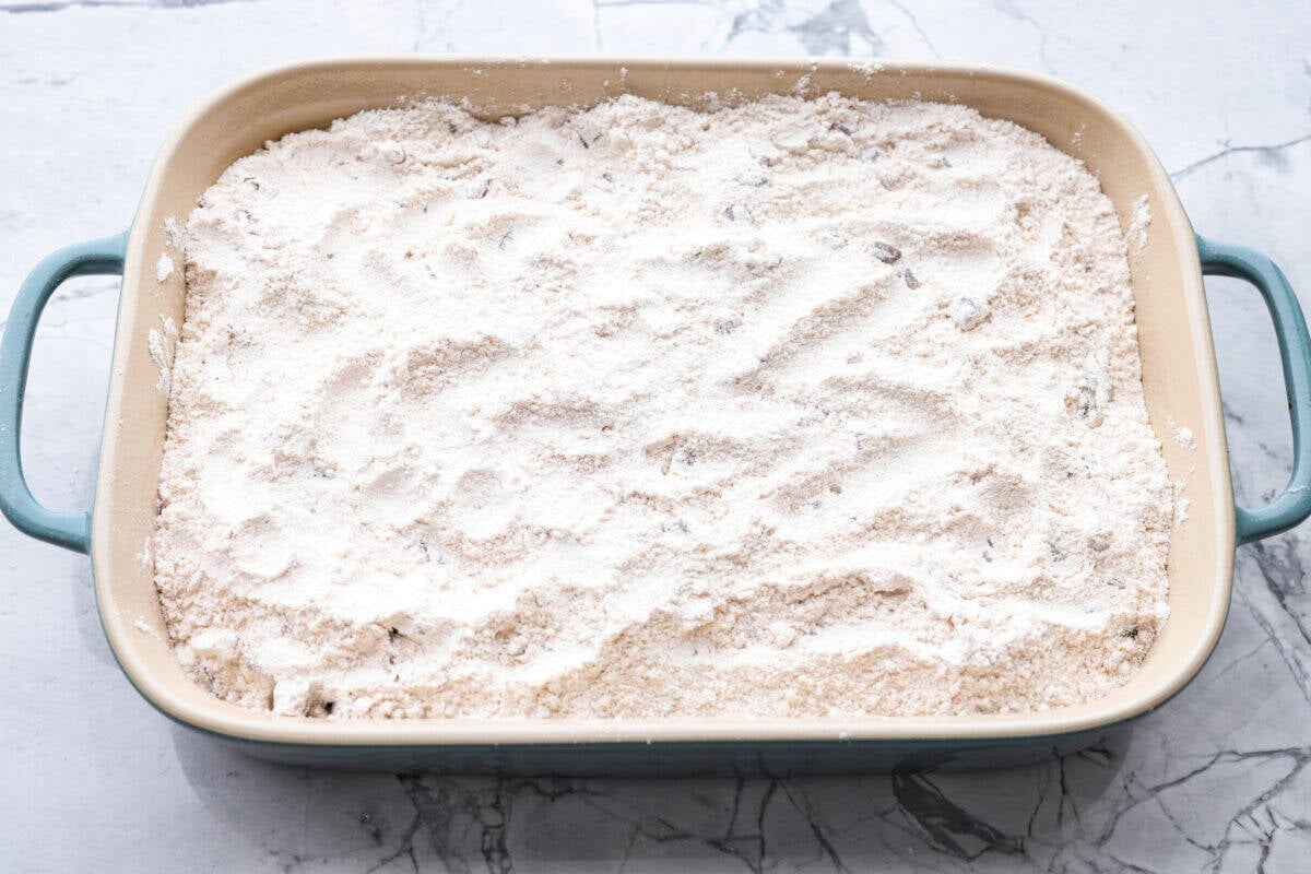 This Apple Dump Cake is your new dessert BFF. You can just toss it together, pop it in the oven, and let the magic happen. Sweet, simple, and seriously so delicious. Cake mix mixture spread out over the apple pie filling.