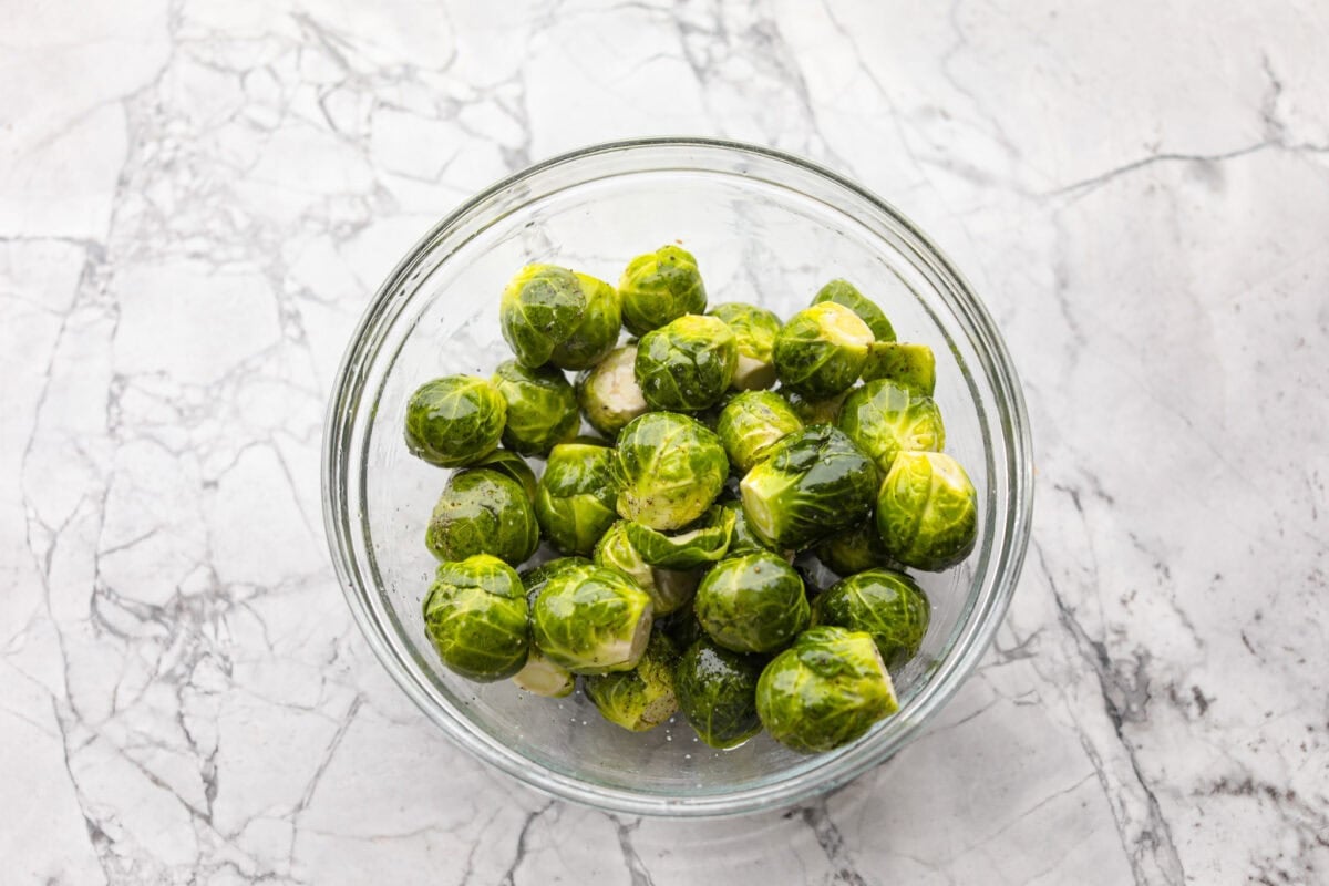 I love bacon. I love Brussels sprouts. Put them together and Iโm sold. But the secret to these bacon-wrapped Brussels sprouts? A drizzle of maple syrup! It makes them sweet, smoky, and completely irresistible. Bowl of washed and trimmed Brussels sprouts.
