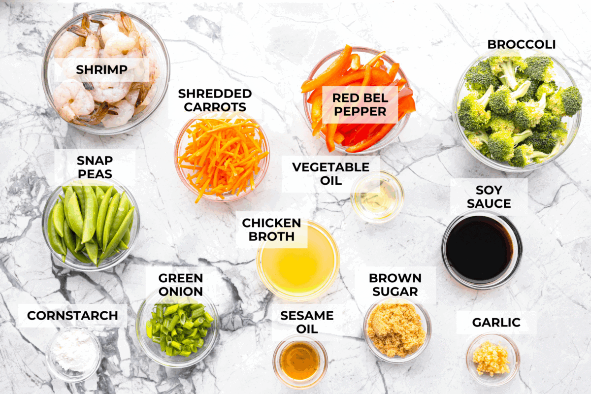 Some nights you just need dinner on the tableย fast! Thatโs when this garlic shrimp stir fry saves the day. Juicy shrimp, crisp veggies, and the BEST garlicky sauce all come together in 20 minutes. Overhead shot of labeled ingredients.