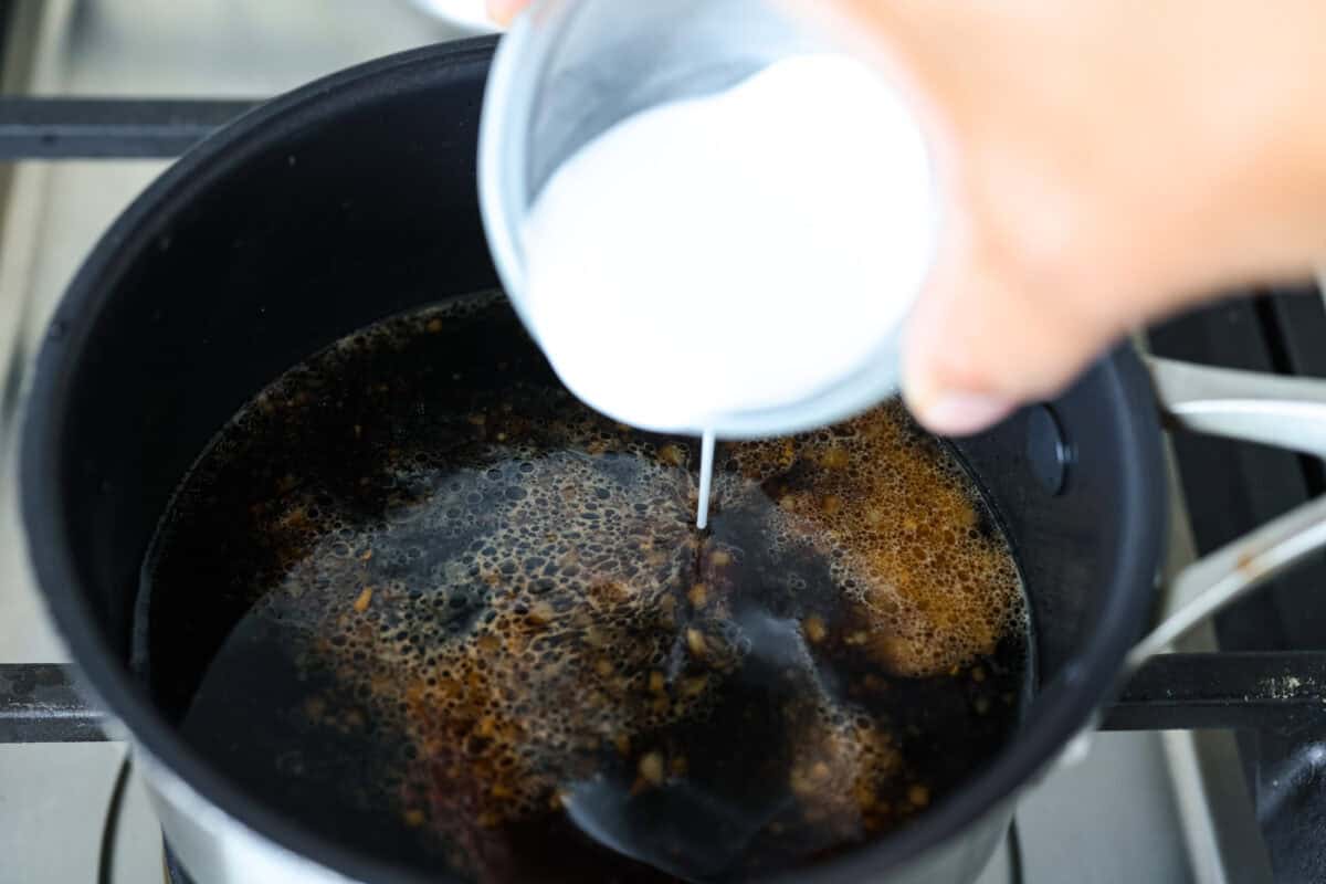 Air fryer teriyaki salmon is the best fast and tasty meal! The salmon cooks up perfectly tender with crisp edges, then gets coated in a glossy, sweet-and-savory teriyaki glaze that I know you'll love! Cornstarch slurry being added to the sauce to thicken it.