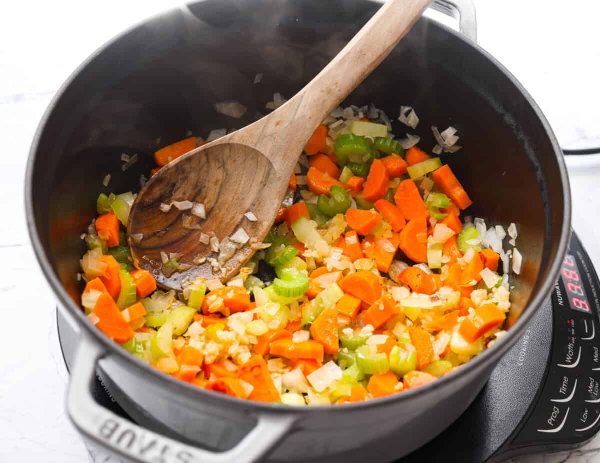 My love of cozy soups kicks in the second summer fades. This creamy tortellini soup gives me all the fall vibes. Fresh veggies, cheesy pasta, and a creamy broth, it's comfort in a bowl. Youโve got to try it today! Carrots, onion, and celery cooking in a pot.