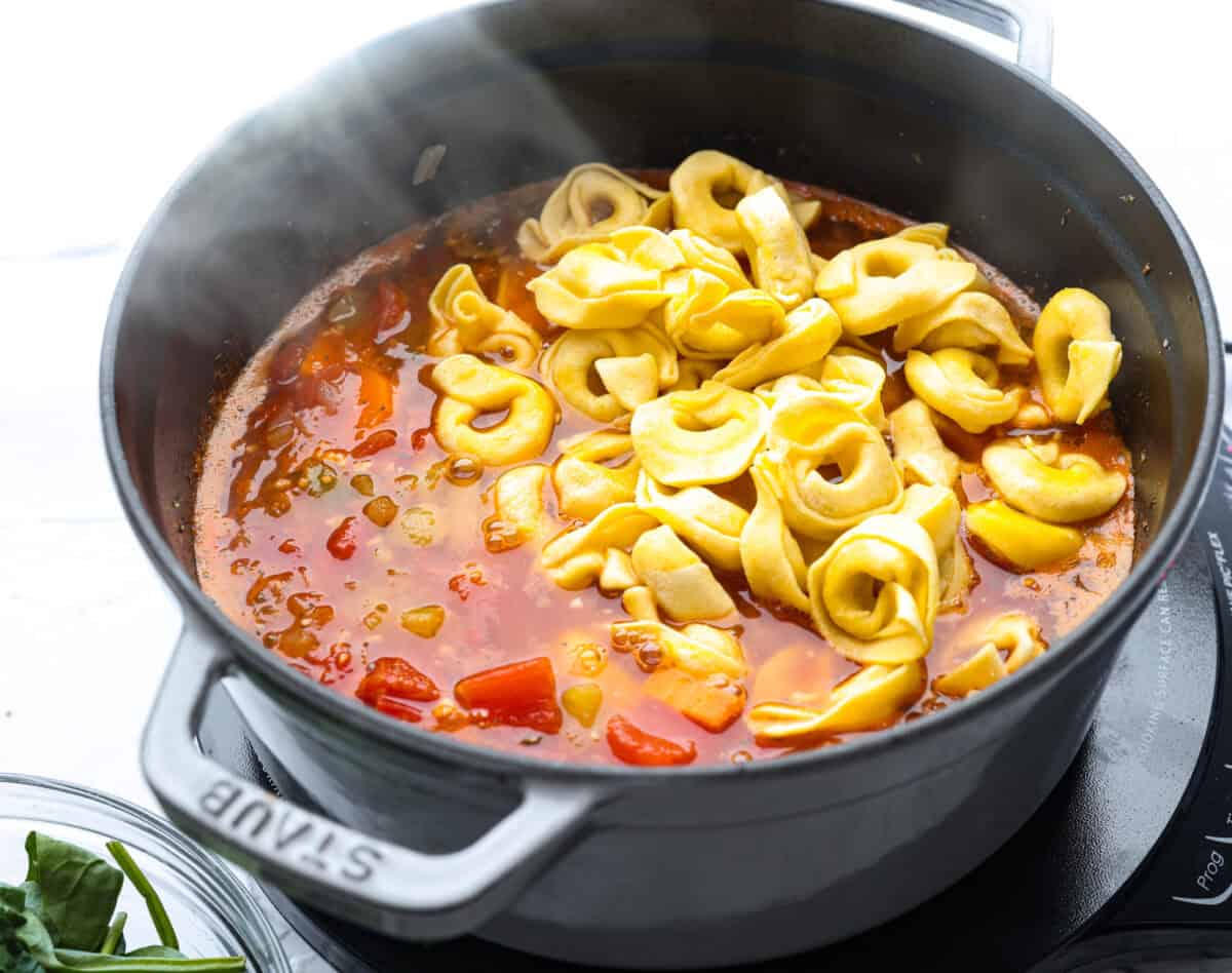My love of cozy soups kicks in the second summer fades. This creamy tortellini soup gives me all the fall vibes. Fresh veggies, cheesy pasta, and a creamy broth, it's comfort in a bowl. Youโve got to try it today! Tortellini added to the broth and veggie mixture.