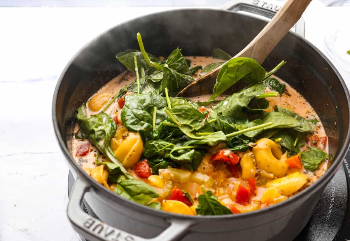 My love of cozy soups kicks in the second summer fades. This creamy tortellini soup gives me all the fall vibes. Fresh veggies, cheesy pasta, and a creamy broth, it's comfort in a bowl. Youโve got to try it today! Cream, cheese and spinach added to the soup.