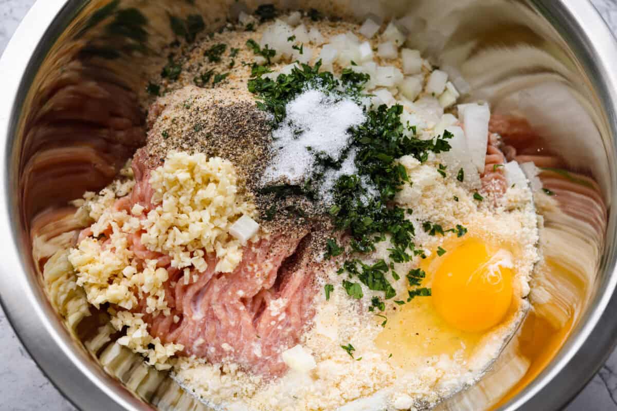 Meet your new favorite meatloaf! The ground chicken makes the Garlic Parmesan Chicken Meatloaf super moist, and you'll love the Parmesan herb-crusted topping! All of the meatloaf ingredients in a bowl before they have been mixed together.
