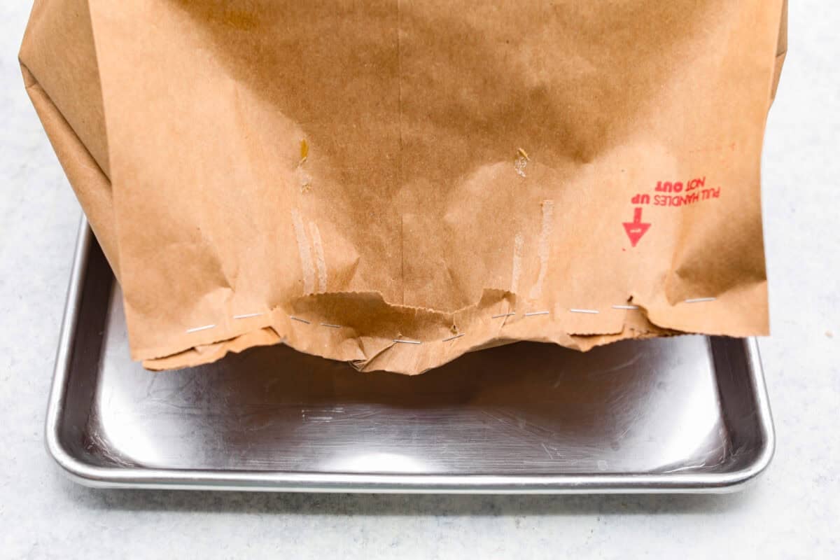 This brown bag apple pie is simple, foolproof, and downright delicious! The secret? It bakes right inside a paper bag, keeping the crust golden, the filling perfectly tender, and your oven mess-free. pictures of the brown bag folded over and stapled shut.