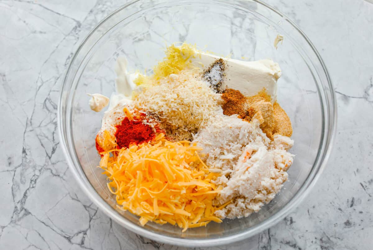 My hot crab dip is one of those recipes you have to try. Itโs creamy, cheesy, and irresistible. Ready in about 30 minutes, itโs my go-to when I want something that feels fancy but takes zero effort. All of the ingredients added to a mixing bowl.