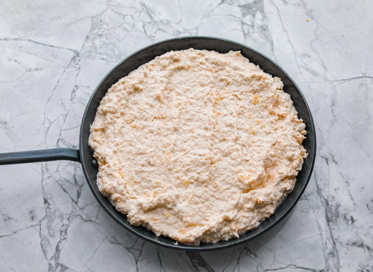My hot crab dip is one of those recipes you have to try. Itโs creamy, cheesy, and irresistible. Ready in about 30 minutes, itโs my go-to when I want something that feels fancy but takes zero effort. All of the ingredients mixed together then added to a cast iron skillet.