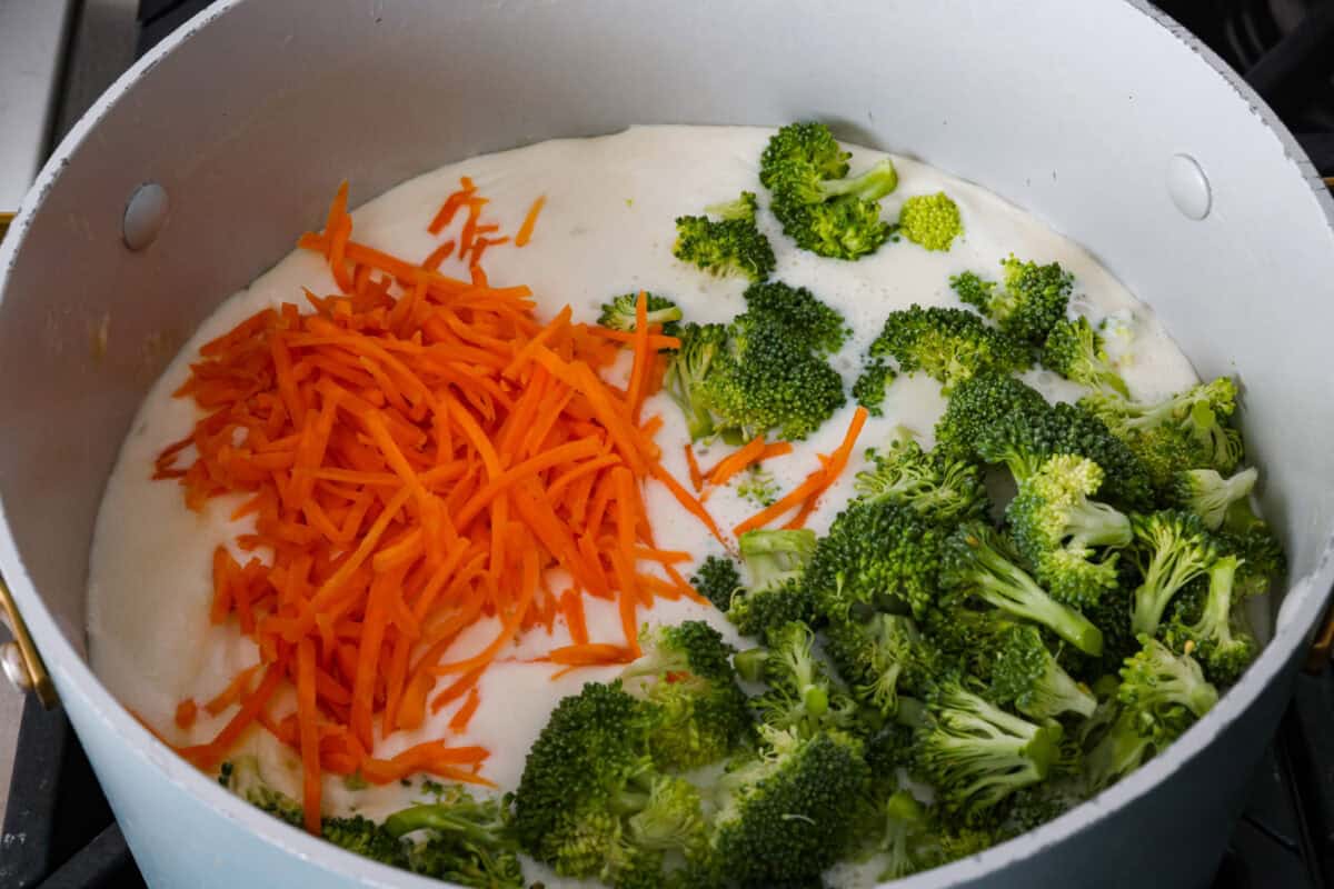 I promise that with just one bite of this copycatย Panera Breadย Broccoli Cheddar Soup, you'll be hooked! It's ultra creamy with broccoli, shredded carrots, and a hint of nutmeg, all cooked together with melted cheese. This soup is delicious and easy to make! Broccoli and carrots added to the soup base.