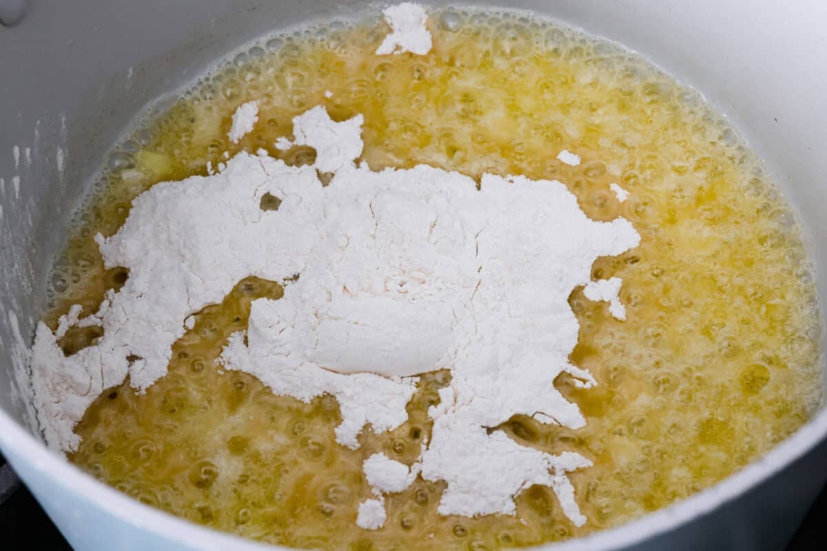 I promise that with just one bite of this copycatย Panera Breadย Broccoli Cheddar Soup, you'll be hooked! It's ultra creamy with broccoli, shredded carrots, and a hint of nutmeg, all cooked together with melted cheese. This soup is delicious and easy to make! Onions, melted butter and flour in pot.