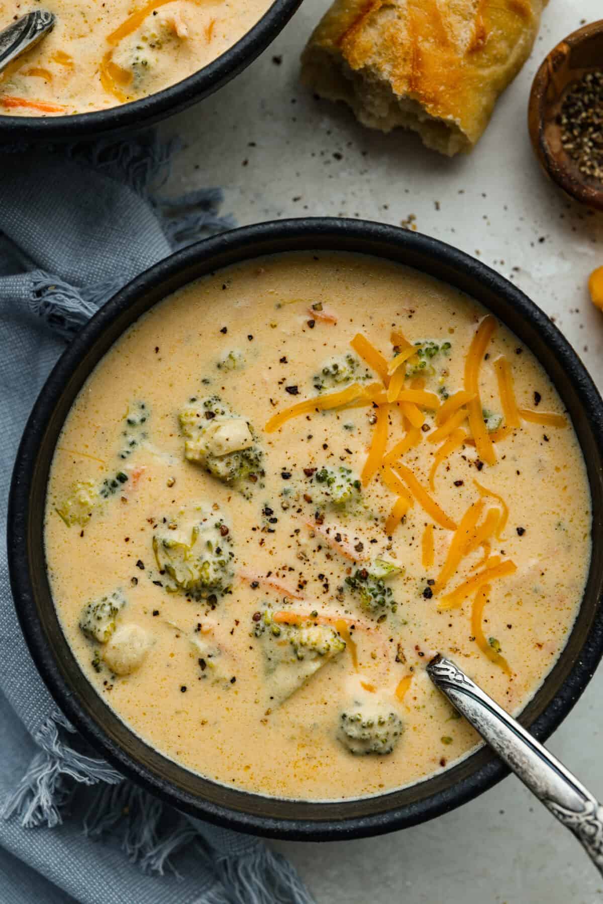 I promise that with just one bite of this copycatย Panera Breadย Broccoli Cheddar Soup, you'll be hooked! It's ultra creamy with broccoli, shredded carrots, and a hint of nutmeg, all cooked together with melted cheese. This soup is delicious and easy to make! Bowl of Panera broccoli cheese soup.