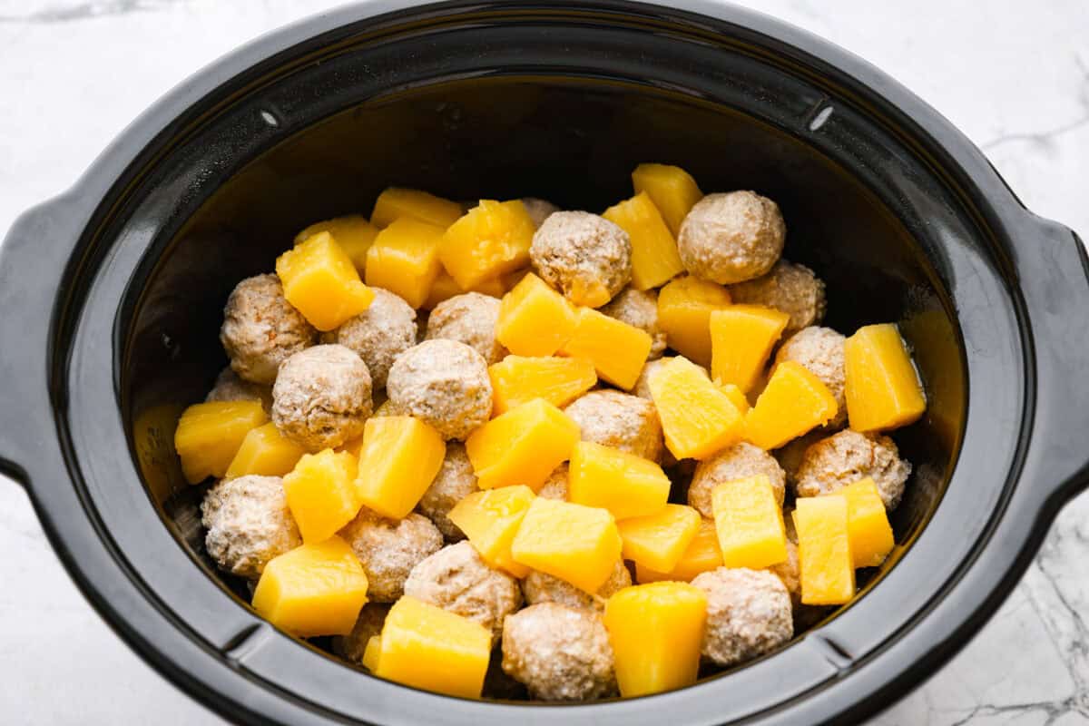 Bring the taste of the tropics to your table with Crockpot Huli Huli Meatballs! Juicy meatballs simmer in a sweet and tangy pineapple-ginger sauce, bursting with island flavor. Pineapple chunks and meatballs in a crockpot.