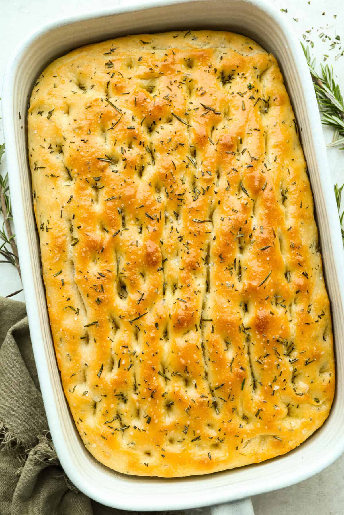 Golden, fluffy, and infused with fresh rosemary and olive oil, this rosemary focaccia is pure perfection! With its crisp edges, soft center, and irresistible herb aroma, it’s the kind of bread that disappears straight off the pan. Baked focaccia in a baking dish.