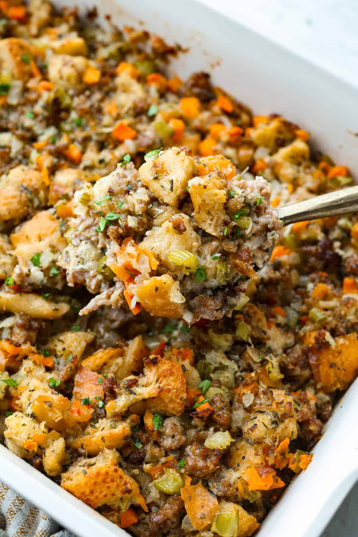 Why did it take me this long to use it in stuffing? Sourdough Stuffing's tangy crustย and the chewy middleย are perfection! Every bite soaks up all that buttery, herby goodness like it was made for this. Close up shot of baked sourdough stuffing.