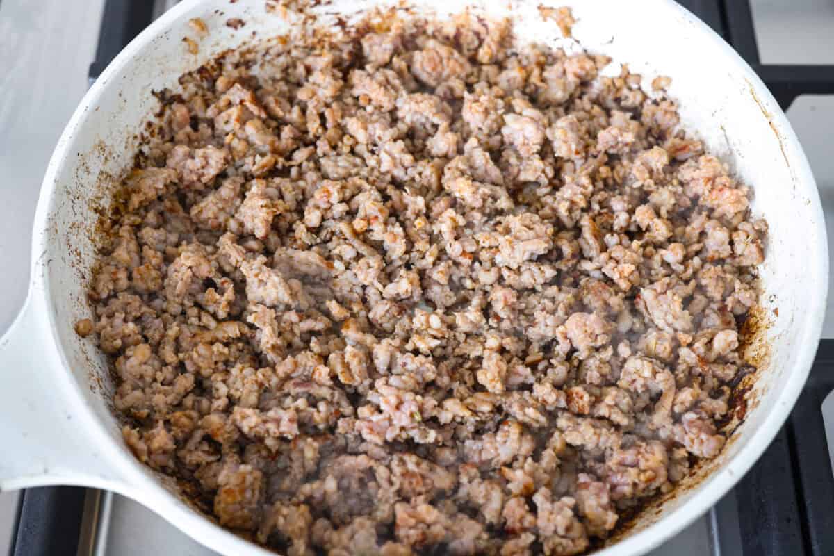 Why did it take me this long to use it in stuffing? Sourdough Stuffing's tangy crustย and the chewy middleย are perfection! Every bite soaks up all that buttery, herby goodness like it was made for this. Sausage cooking in a skillet.