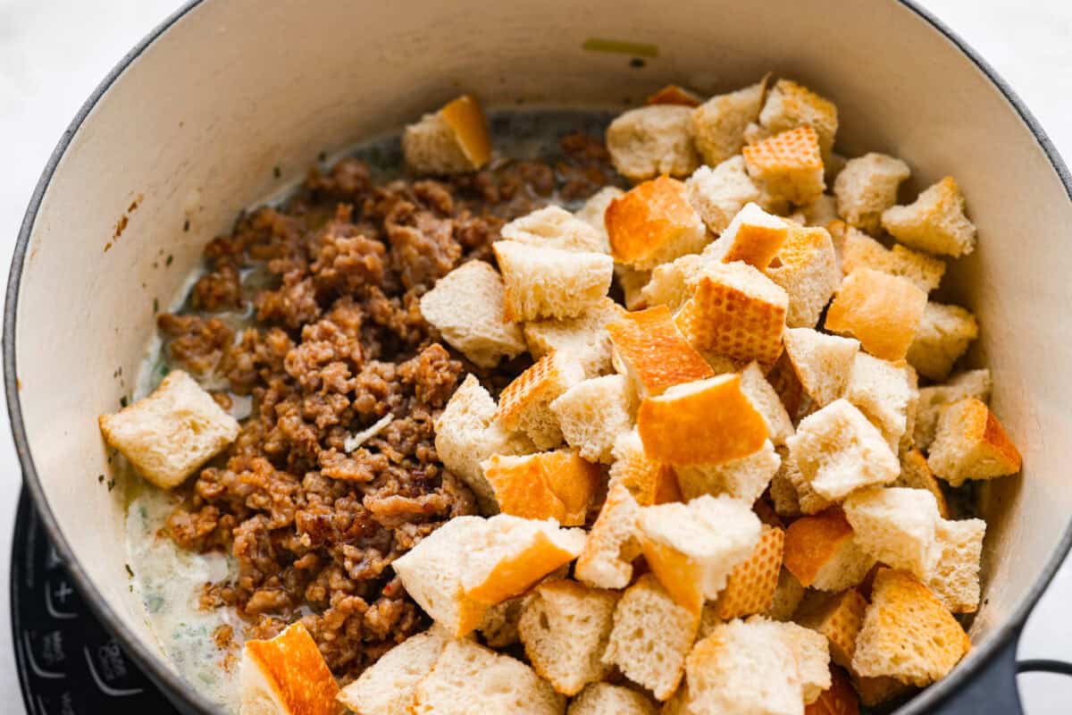 Why did it take me this long to use it in stuffing? Sourdough Stuffing's tangy crustย and the chewy middleย are perfection! Every bite soaks up all that buttery, herby goodness like it was made for this. Sausage and bread added to the broth and herb mixture.