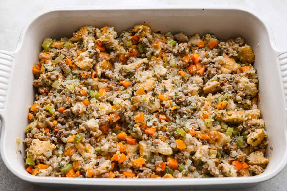 Why did it take me this long to use it in stuffing? Sourdough Stuffing's tangy crustย and the chewy middleย are perfection! Every bite soaks up all that buttery, herby goodness like it was made for this. Sourdough stuffing in the baking dish ready to go in the oven.