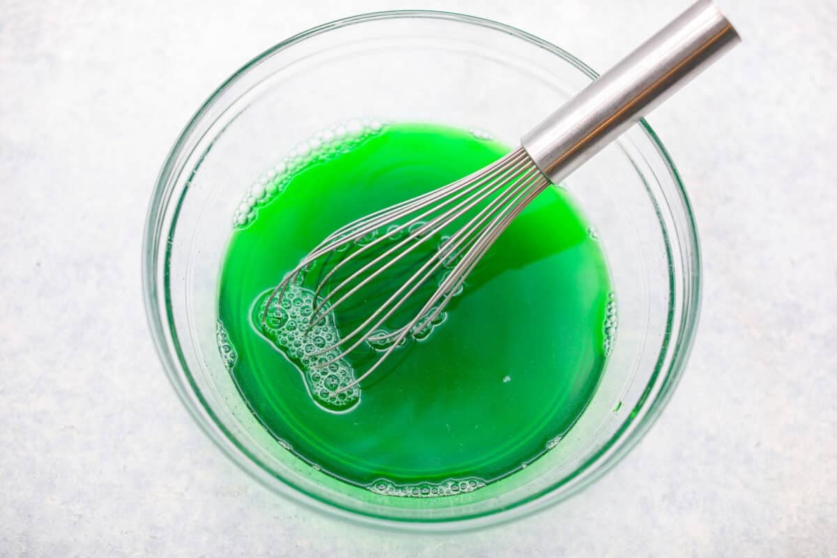 This Christmas ribbon salad brings all the festive vibes with its bright, sliceable layers. It looks fancy, but the process is super easy and mostly hands-off. Make it ahead and watch it disappear! Lime Jello whisked with boiling water in a larg mixing bowl.