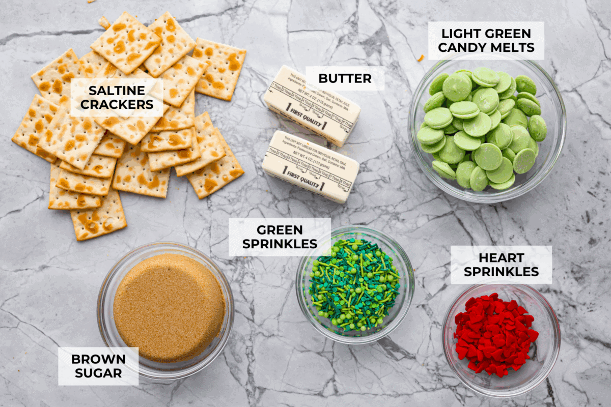 If you want a quick, crunchy treat with a bit of holiday mischief, this Grinch Christmas Crack is it. Sweet, salty, and totally addictive. My classic Christmas Crack is always a hit, but this version brings all the Grinchy fun! Overhead shot of labeled grinch Christmas crack ingredients.