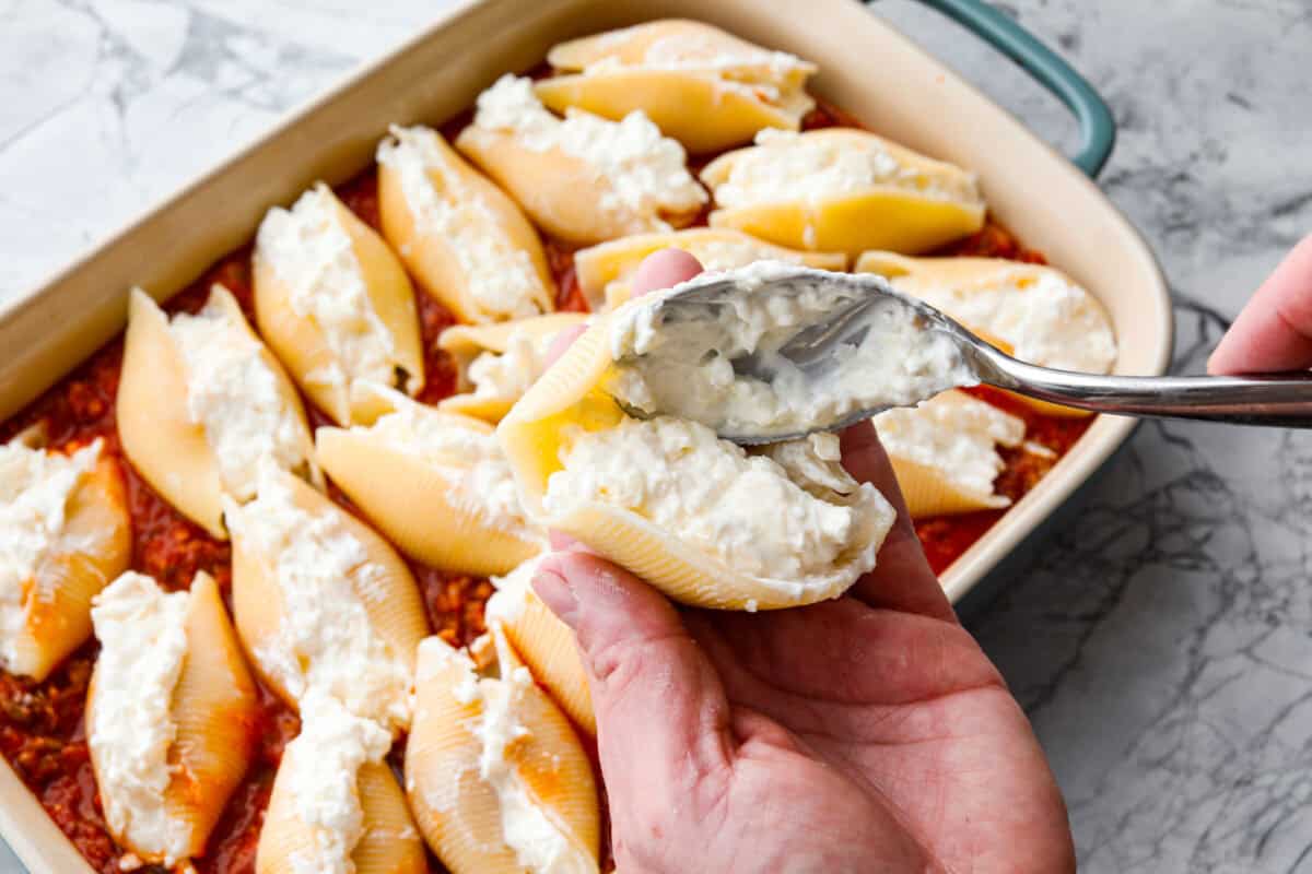 https://www.target.com/p/rao-39-s-homemade-marinara-sauce-premium-quality-all-natural-tomato-sauce-38-pasta-sauce-keto-friendly-38-carb-conscious-24oz/-/A-13349580#lnk=sametab Someone adding a spoonful of million dollar mixture into a jumbo pasta shell.