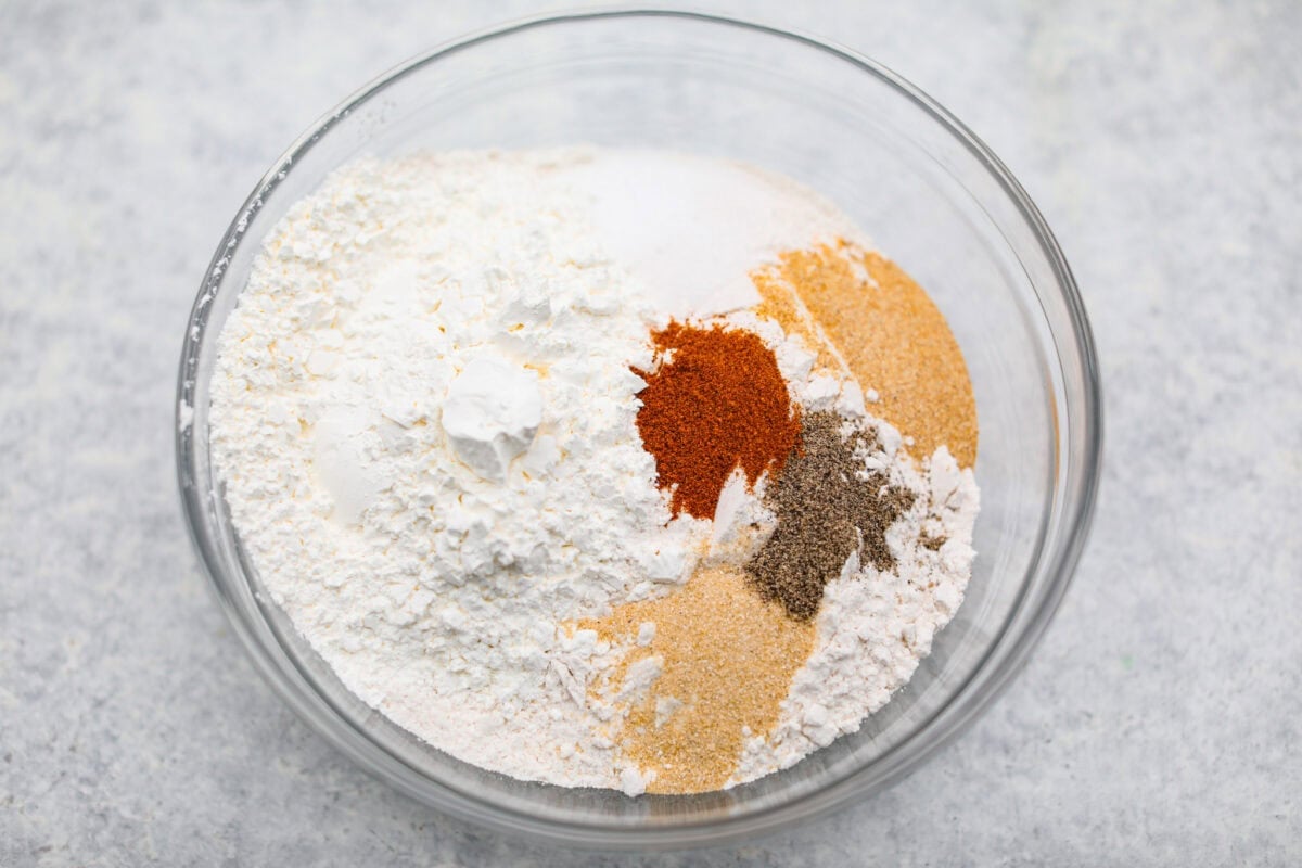 Make this copycat Raising Cane’s chicken tenders at home, no drive-thru required. An easy marinade, simple ingredients, and a quick fry give you crisp, light chicken and that unmistakable Cane’s sauce for a fraction of the cost. Flour and seasonings added to a mixing bowl.