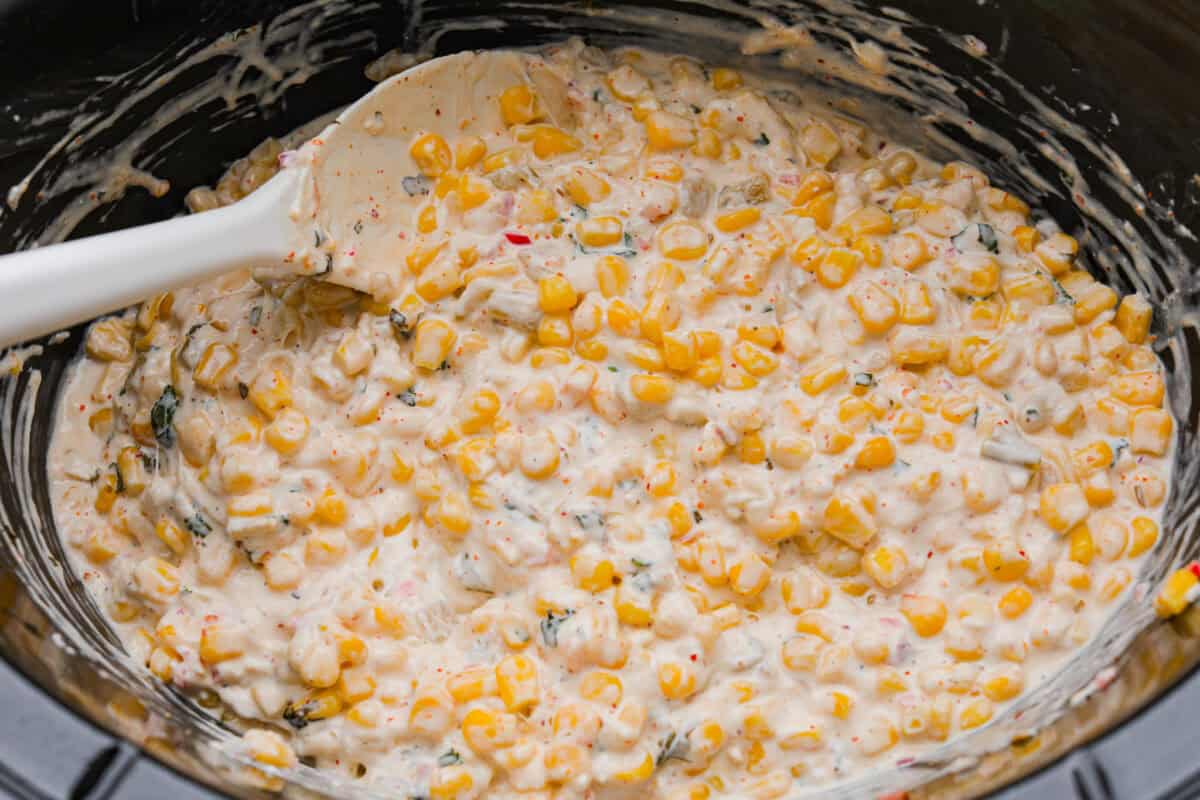 My slow cooker Mexican street corn dip takes all the flavors of elote and turns them into a warm, creamy, cheesy dip. Just toss everything in the crockpot and let it do the work. All of the ingredients warmed and melted together in the slow cooker.