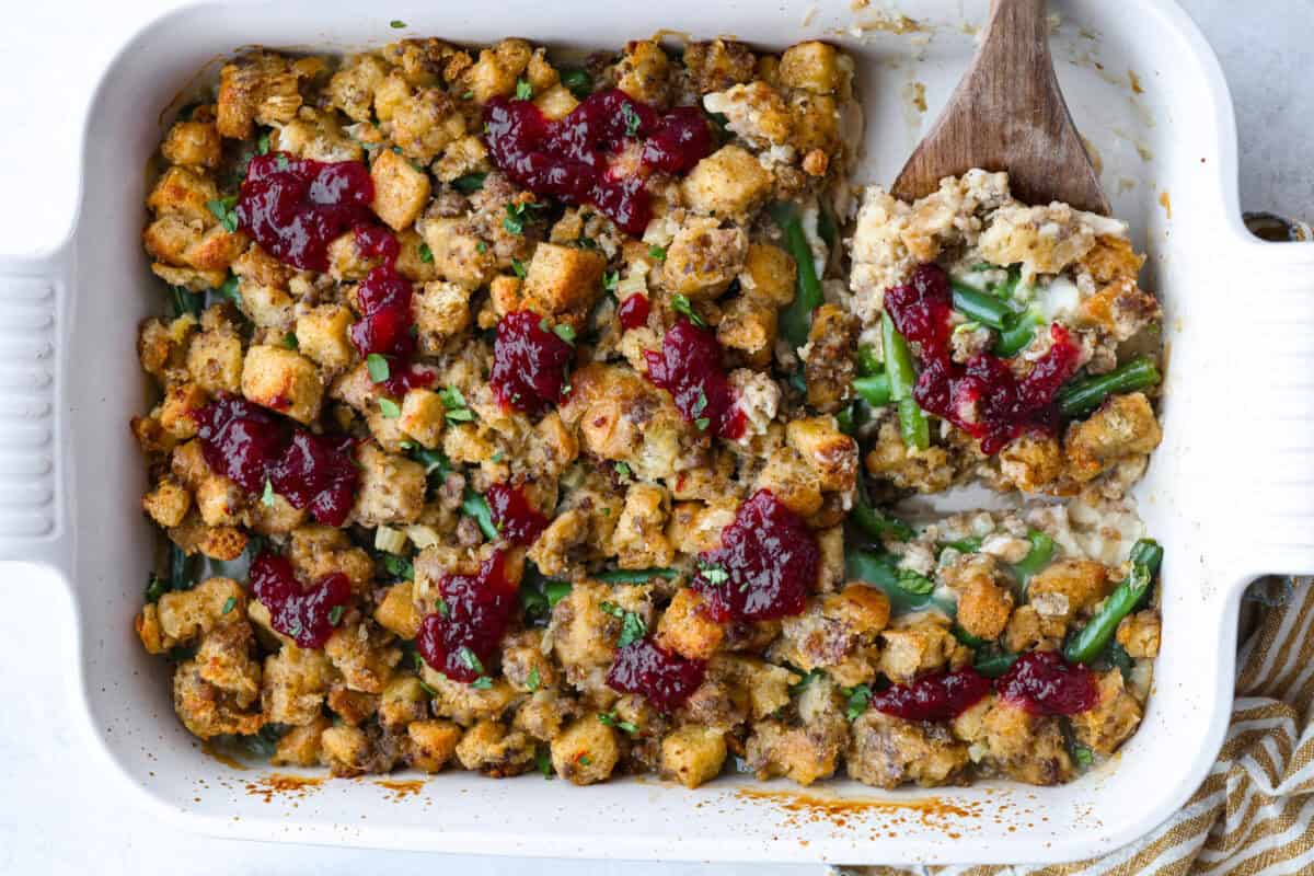 This Thanksgiving leftover casserole is the best way to enjoy every last bit of your holiday meal. I give you tips for keeping it moist, flavorful, and perfectly layered. Thanksgiving leftover casserole all baked and topped with dollops of cranberry sauce.