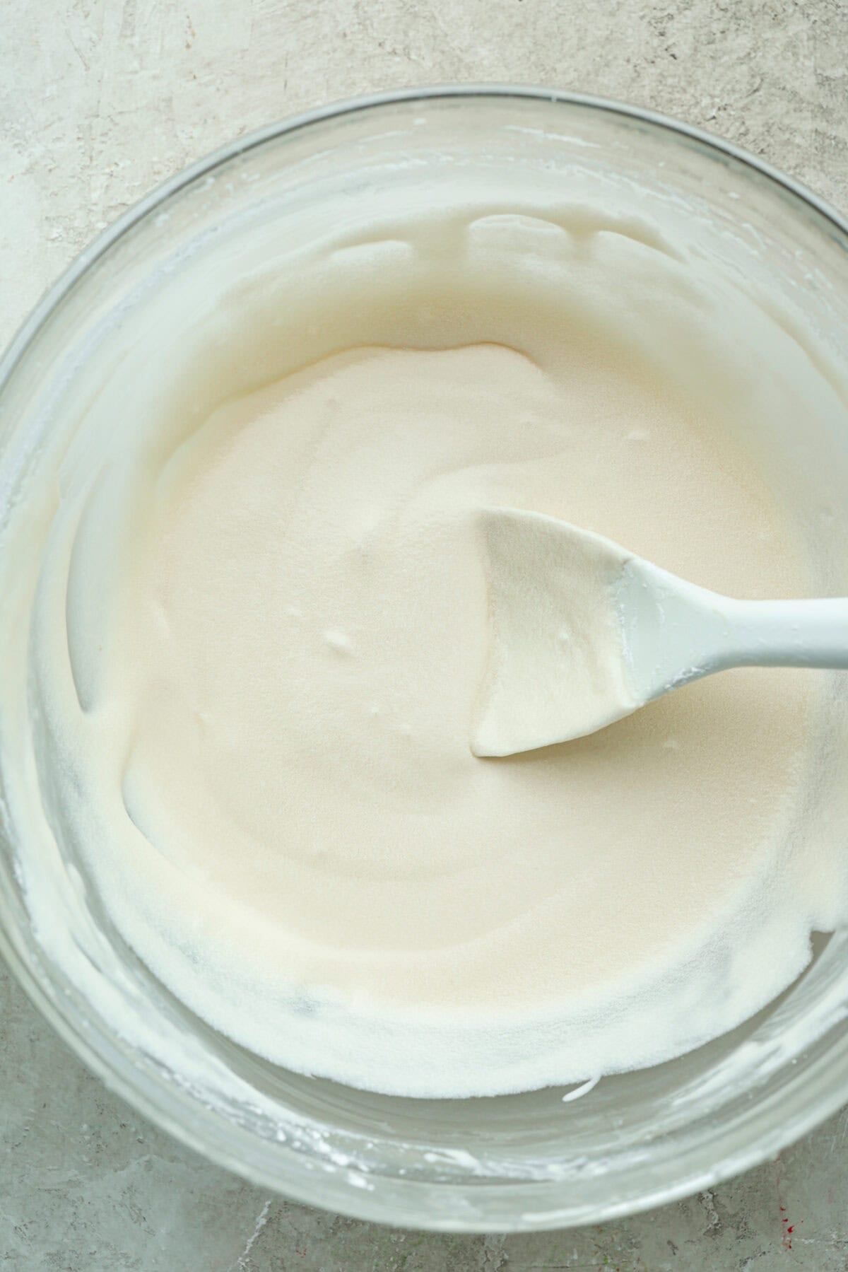 My cinnamon roll icing is what you make when you want real butter flavor. It’s smooth, quick, and made from pantry staples. Think buttercream, but lighter, warmer, and made to melt into every swirl. Bowl of Cinnamon roll icing with a silicone spoon.