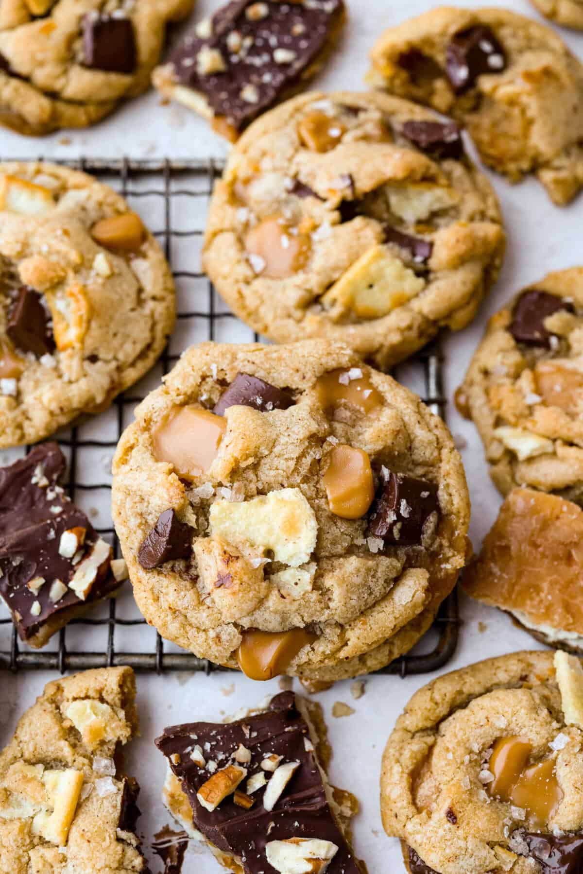 Skip the candy making! These Christmas Crack Cookies give you all the buttery, chocolatey, toffee filled flavor of Christmas crack in one easy cookie recipe. Gooey, salty, and completely irresistible. Close up shot of Christmas crack cookies stacked on a cooling rack.