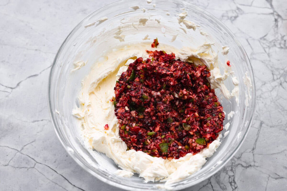 This cranberry jalapeño dip is my fresh take on the cult favorite Costco version. It's bright, tangy, a little spicy, and wildly easy to make at home. It’s the same addictive flavor, but you get to make it how you like! Cranberry mixture added to the cream cheese mixture.