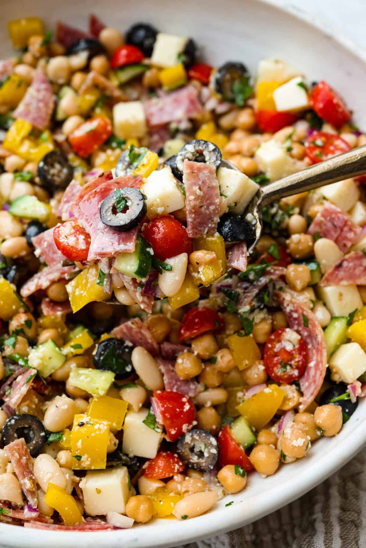 TikTok creator Violet Witchel made this dense bean salad go viral for good reason. Itโs simple, high in fiber, protein-packed, and stays delicious for days. My version keeps the same hearty texture and zesty flavor that made her trend explode. Close up of a spoonful of dense bean salad.